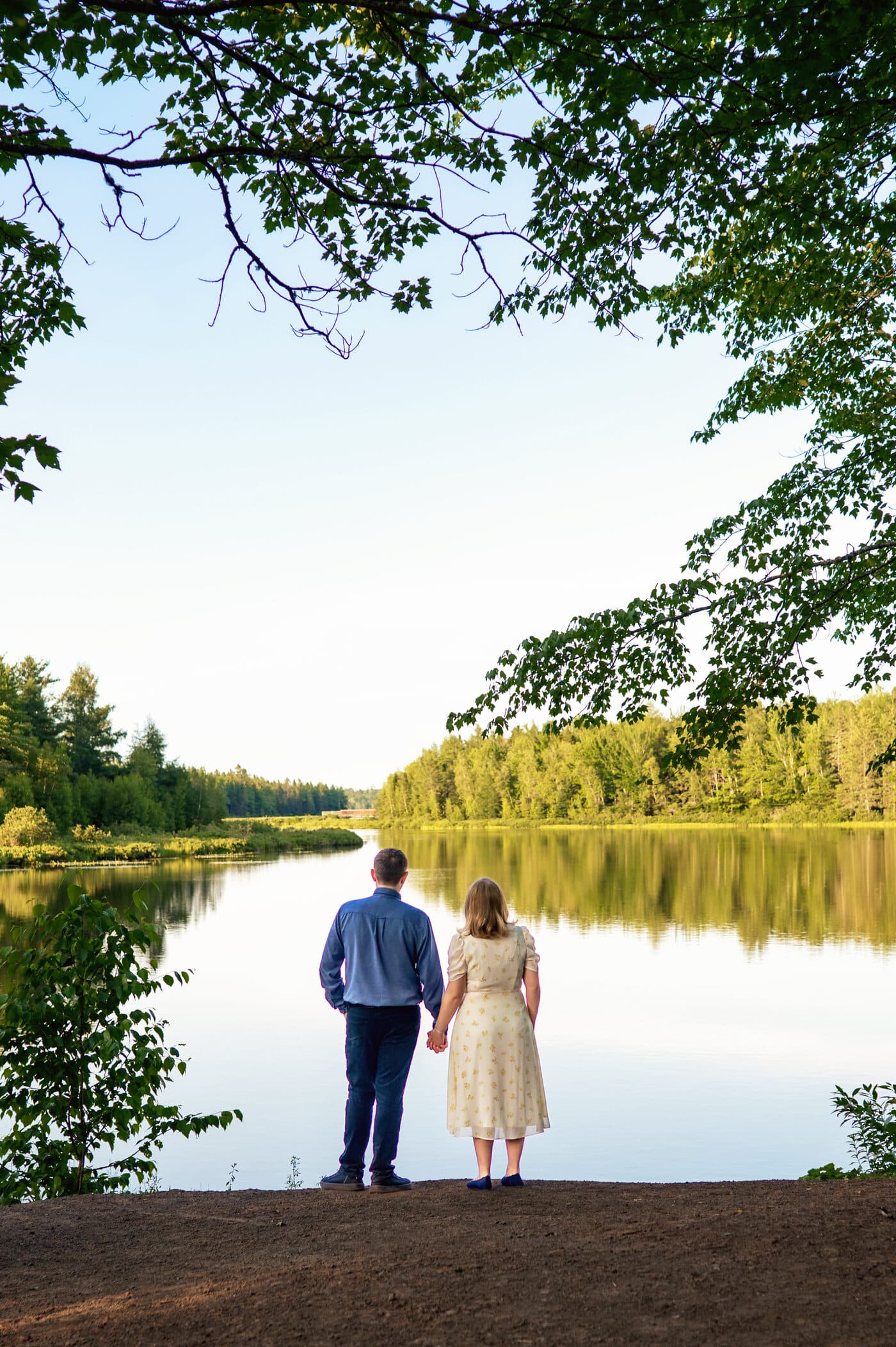 Alexandra and Jérémy holding hands at the edge of a lake