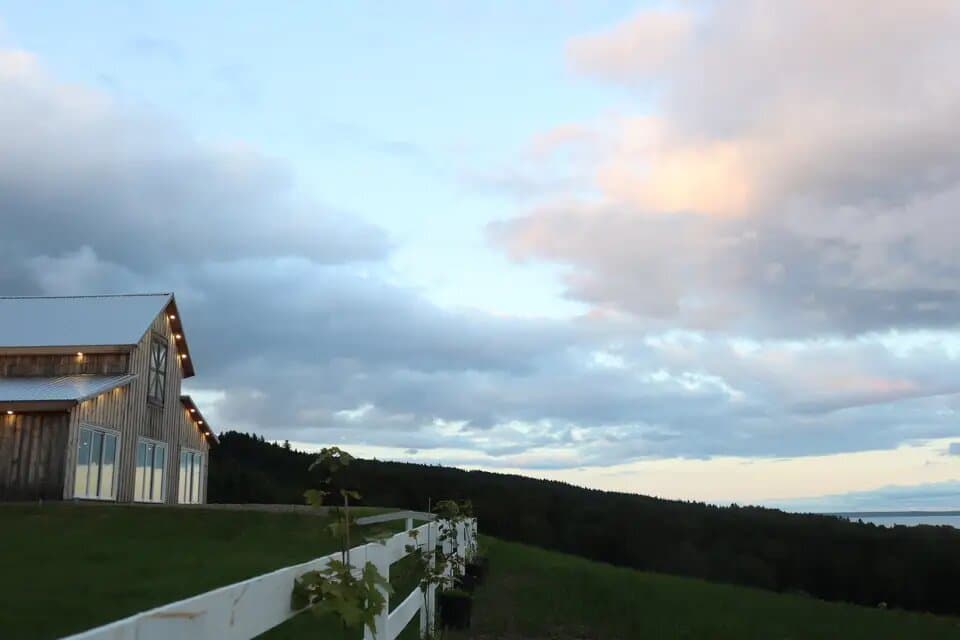 The barn at Hopewell Highlands at dusk, overlooking the forest and bay